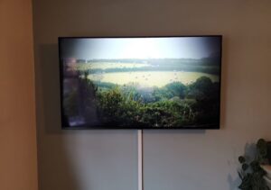 A professional TV mounted on the wall in a Cape Coral living room, showcasing a clean and organized space with hidden cables.