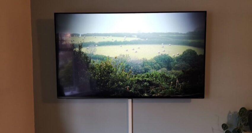 A professional TV mounted on the wall in a Cape Coral living room, showcasing a clean and organized space with hidden cables.