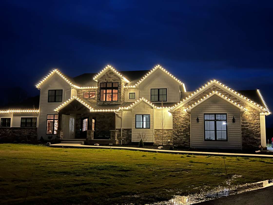 Beautiful Sarasota home adorned with residential holiday lighting, featuring roofline and pathway illumination.