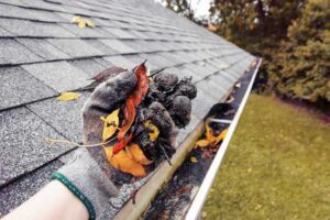 A technician providing emergency gutter cleaning service on a home in Atlanta.