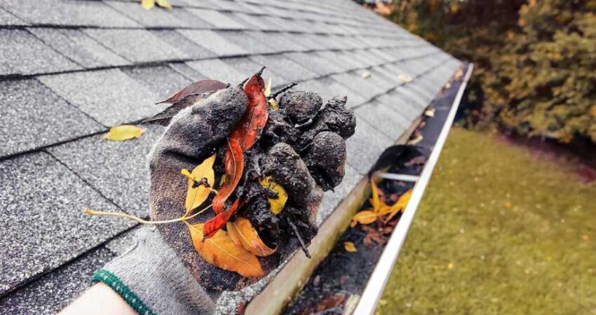 A technician providing emergency gutter cleaning service on a home in Atlanta.